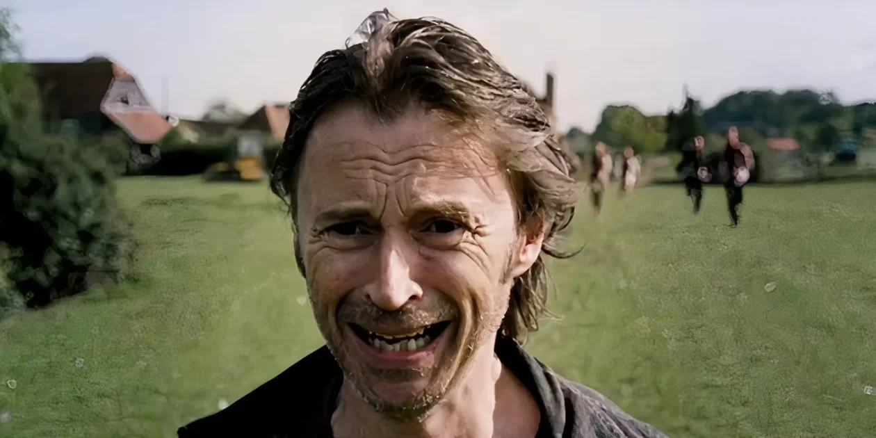 A close-up of Robert Carlyle as an infected character with a wide, desperate grin.