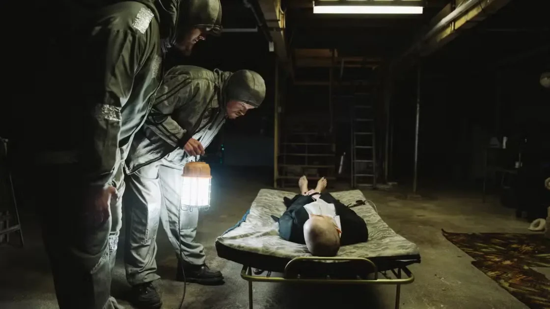 Teddy and Don in silver suits during Bugonia kidnapping scene, image courtesy of Focus Films